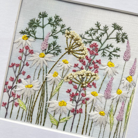 Embroidered artwork of flowers on a white background