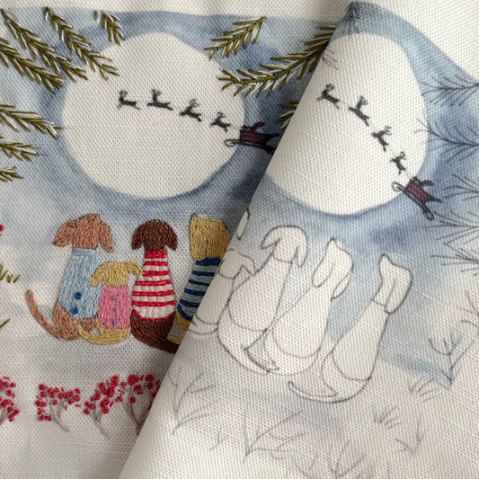 Embroidered fabric with winter-themed design featuring a moon, trees, and animals.