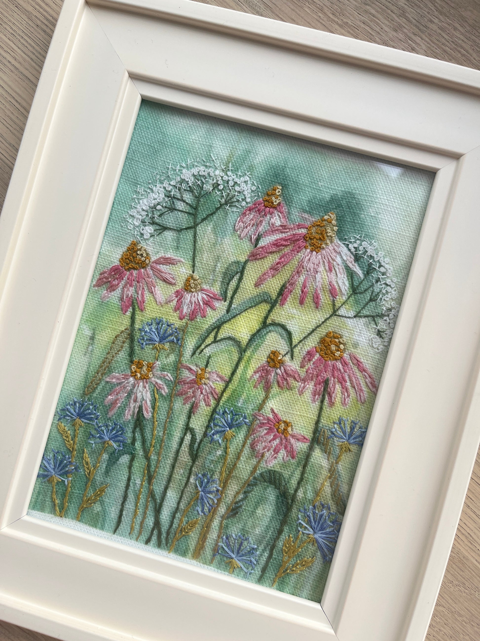 Framed artwork of flowers on a wooden surface