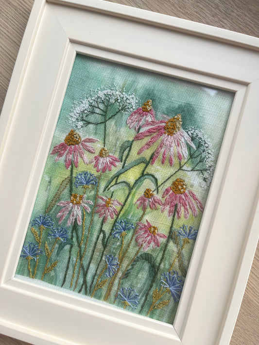 Framed artwork of flowers on a wooden surface