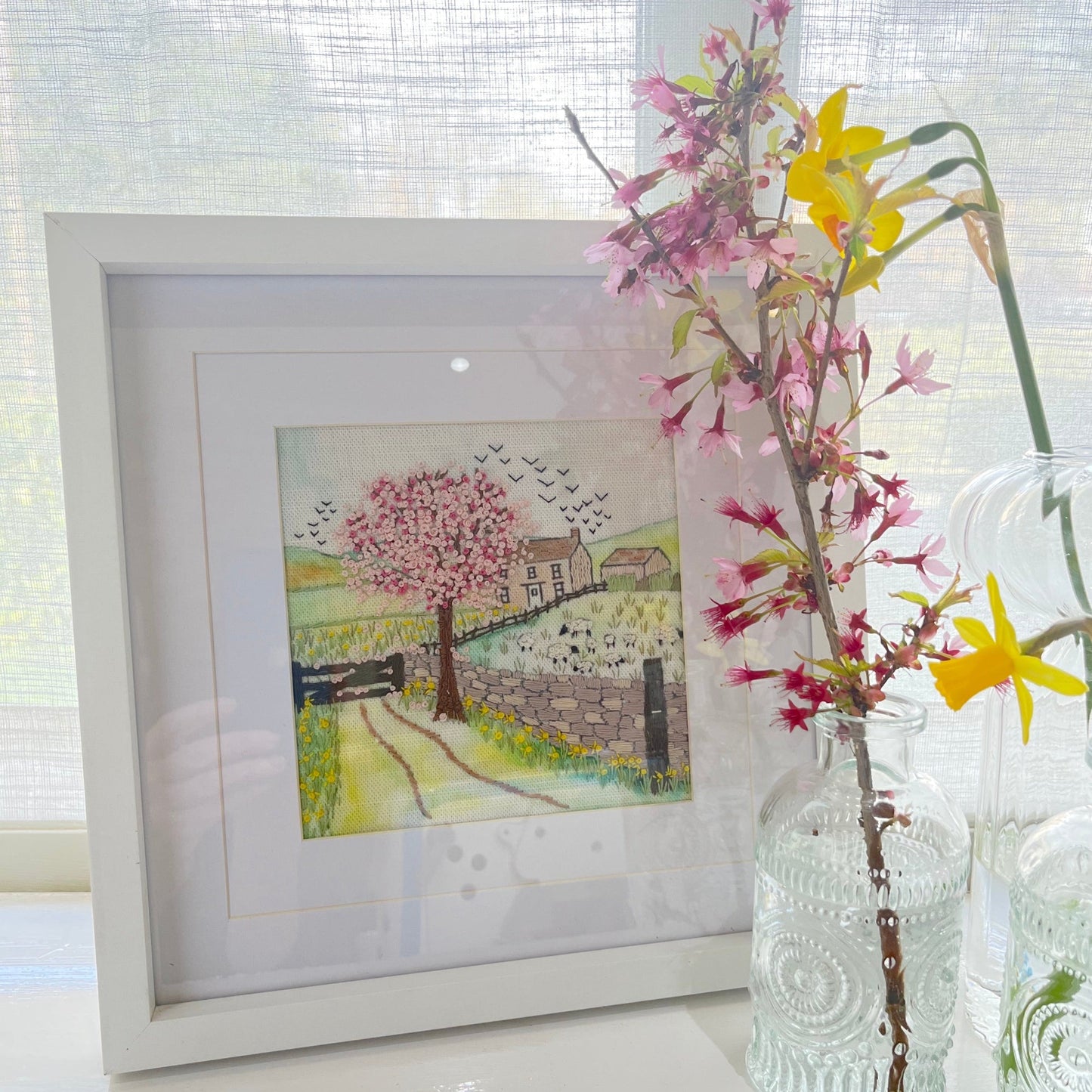 Framed artwork of a cherry blossom scene with flowers in the foreground.